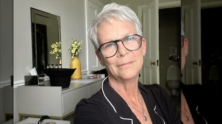Jamie Lee Curtis portant un pyjama noir et des lunettes noires sur un selfie.