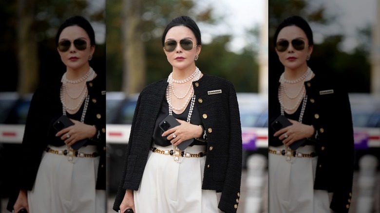 Une femme plus âgée accessoirisant avec des colliers de perles tendance