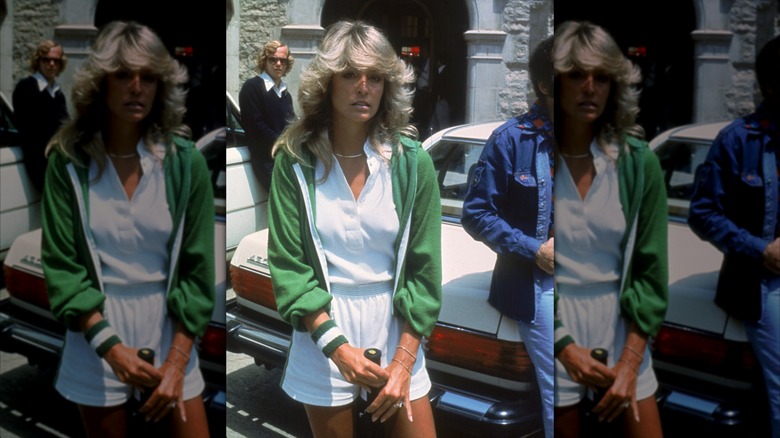 Farrah Fawcett porte une tenue de tennis blanche et une veste verte