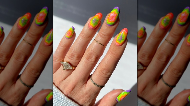 Une photo en gros plan d’une manucure tie-dye colorée.