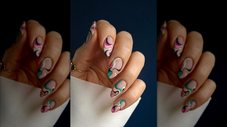 Gros plan d'une manucure avec des tourbillons colorés.