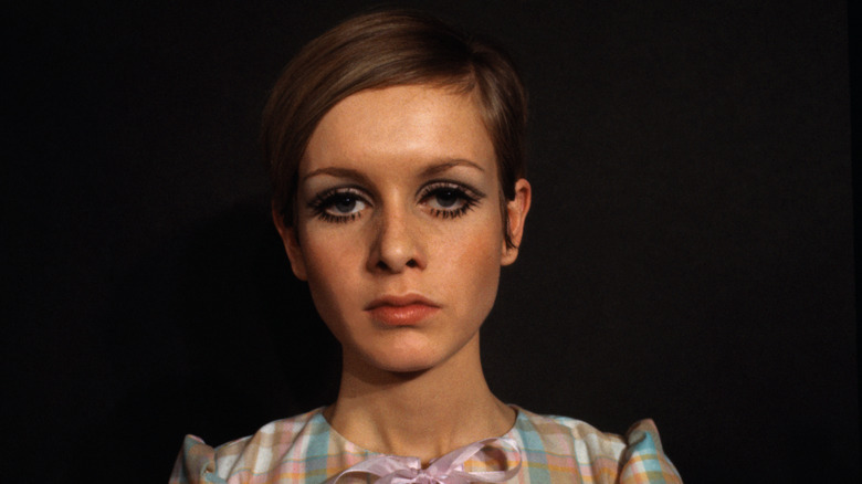 Twiggy pose pour une séance photo avec un maquillage pour les yeux audacieux et une chemise à carreaux vichy