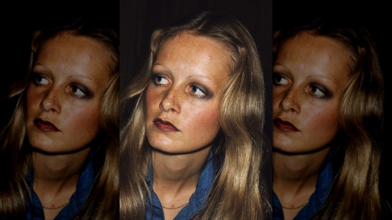 Twiggy regarde vers la gauche, vêtue d'une chemise bleue et d'un maquillage pour les yeux charbonneux.
