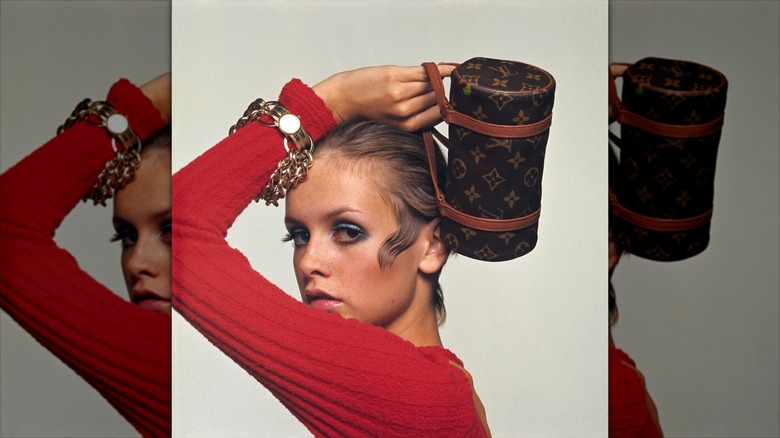 Twiggy pose pour une séance photo avec un fard à paupières bleu et un haut rouge