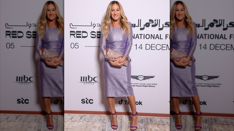 Sarah Jessica Parker posant lors d'un événement portant une robe à manches longues de couleur lilas en 2024.