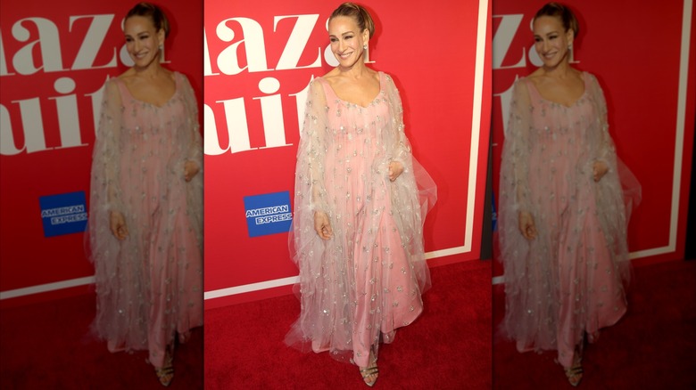 Sarah Jessica Parker souriante lors d'un événement sur le tapis rouge vêtue d'une robe rose fluide en 2022.