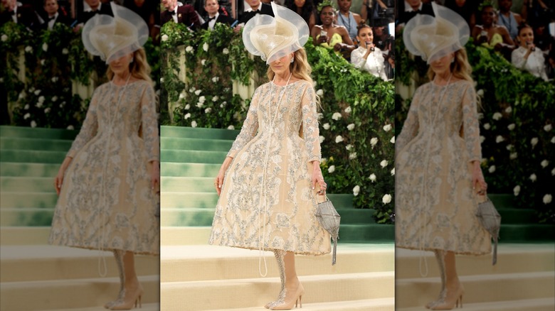 Sarah Jessica Parker posant au Met Gala en 2024 dans une robe dorée complexe avec un grand chapeau.