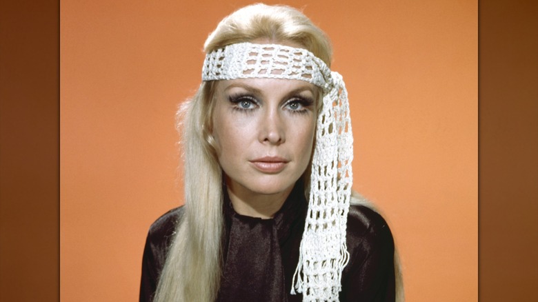 Barbara Eden pose avec un bandeau blanc en crochet