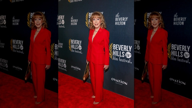 Barbara Eden sourit dans un tailleur-pantalon rouge