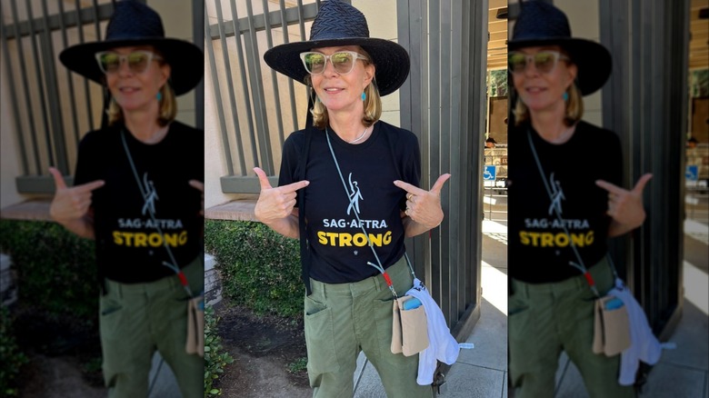 Allison Janney posant dans une photo franche, montrant sa chemise SAG-AFTRA tout en portant des lunettes de soleil et un chapeau noir.