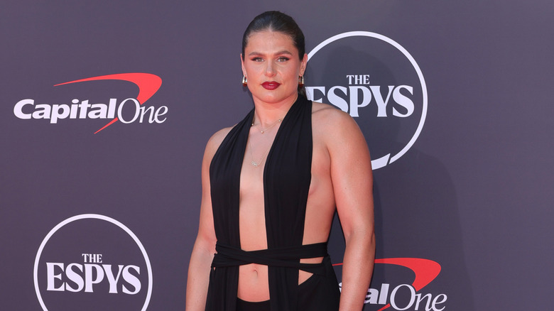 Ilona Maher posant sur le tapis rouge dans une robe noire découpée avec ses cheveux en queue de cheval à l'ESPYS.