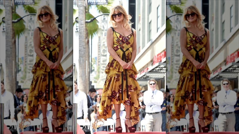 Goldie Hawn porte une robe à volants moutarde et des lunettes de soleil