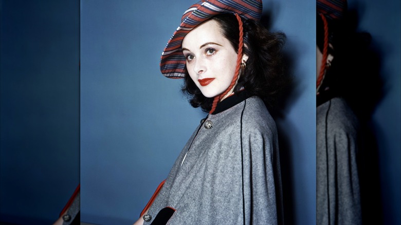 Hedy Lamarr porte un chapeau rayé et un manteau gris