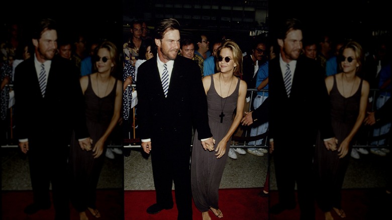 Dennis Quaid pose avec Meg Ryan qui porte une robe grise et des lunettes de soleil.