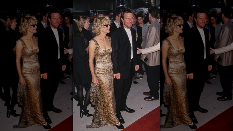 Meg Ryan dans une robe dorée avec des lunettes de soleil posant avec Dennis Quaid en costume lors d'un événement sur le tapis rouge.