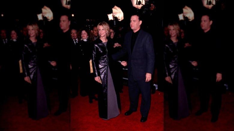 Meg Ryan portant une veste en cuir longue au sol, à côté de Tom Hanks sur le tapis rouge.