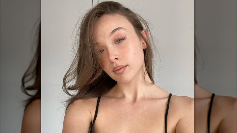 Ella Beatty prend un selfie, vêtue d'un haut noir avec un minimum de maquillage