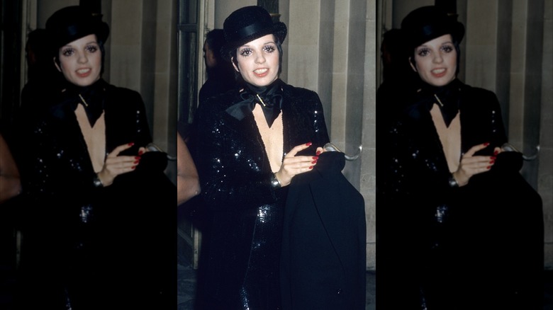 Liza Minnelli porte une tenue entièrement noire scintillante avec un chapeau melon noir.