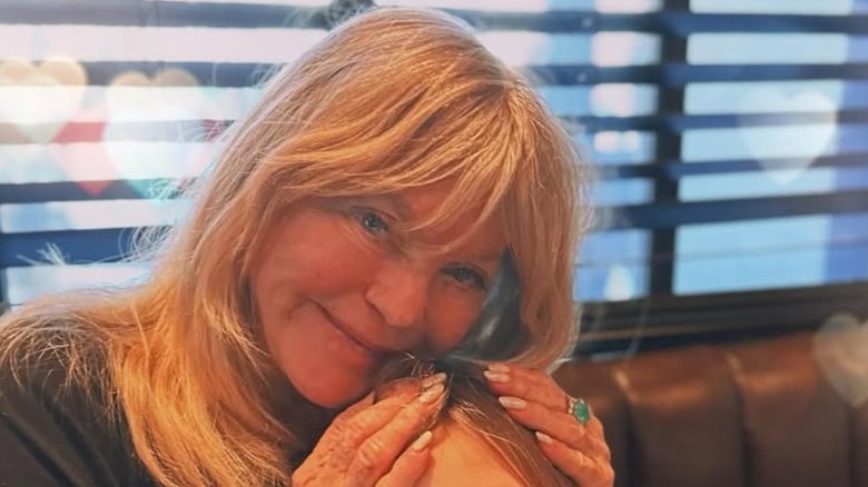 Goldie Hawn posant avec ses mains sur la tête de sa petite-fille sur une photo franche.