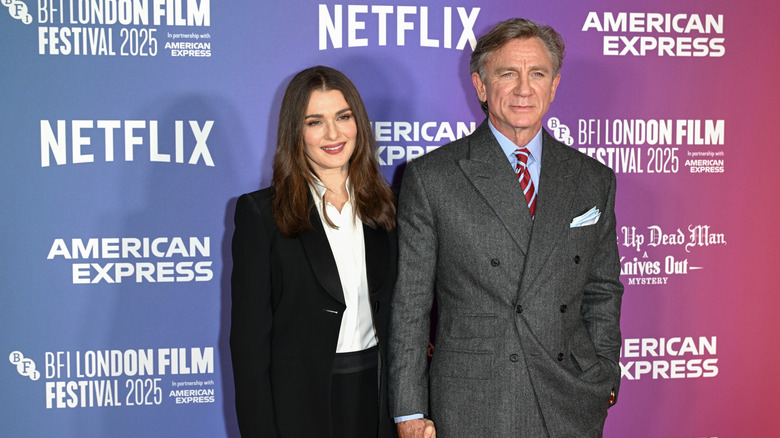 Rachel Weisz portant un costume noir posant avec Daniel Craig