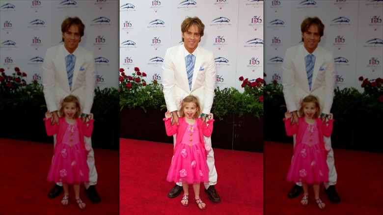 Dannielynn Birkhead sourit devant Larry Birkhead vêtue d'une robe rose vif