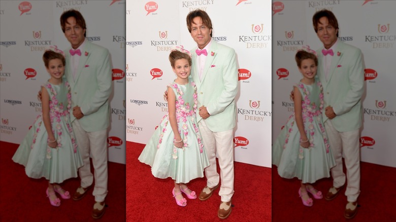 Dannielynn Birkhead sourit à côté de Larry Birkhead vêtue d'une robe à fleurs vert menthe