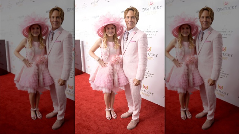 Dannielynn Birkhead se tient à côté de Larry Birkhead, vêtue d'une robe et d'un chapeau roses.