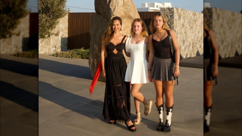 Jessica Alba posant dehors dans une robe noire avec ses filles Honor et Haven.