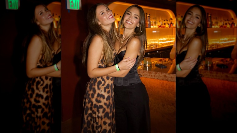 Jessica Alba serre sa fille Honor dans ses bras et pose pour une photo dans un bar.