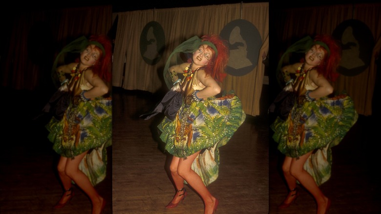 Cyndi Lauper porte une robe verte détaillée et un bandeau foulard vert et danse aux Grammys.