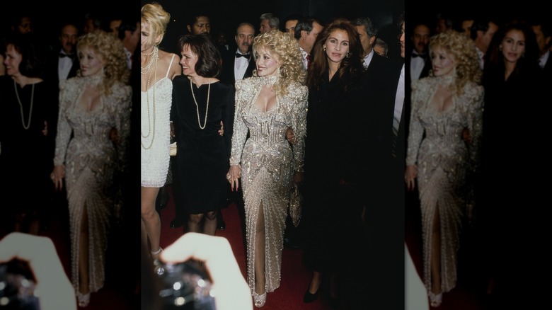 Dolly Parton portant une robe blanche ornée et Julia Roberts portant une robe noire sur le tapis rouge.