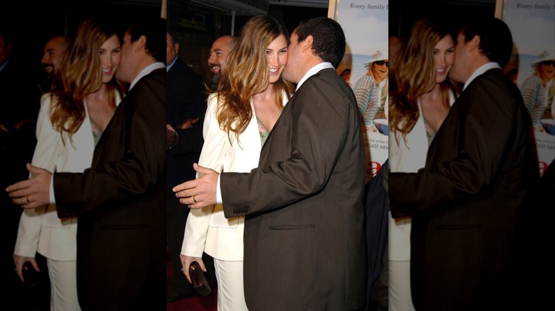 Jackie Sandler sourit tandis qu'Adam Sandler lui chuchote à l'oreille