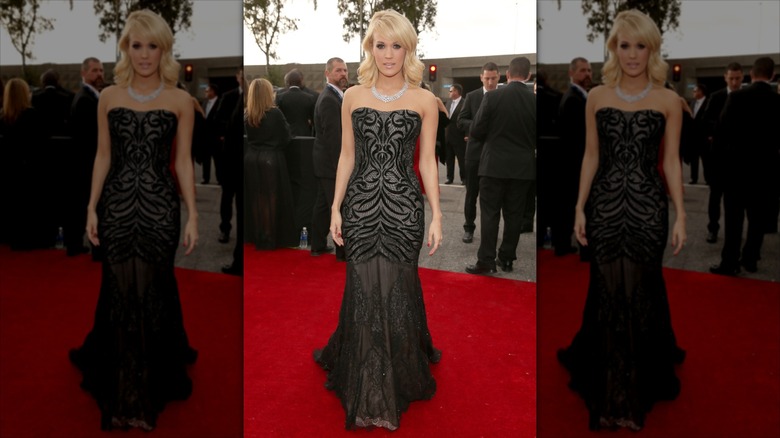 Carrie Underwood pose vêtue d'une robe noire sans bretelles