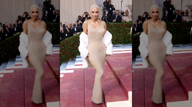 Kim Kardashian pose vêtue d'une robe nude et d'un manteau de fourrure blanc