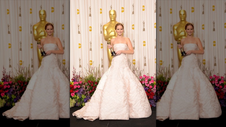 Jennifer Lawrence détient un Oscar dans une robe de bal blanche