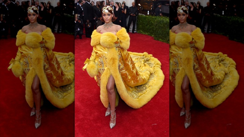 Rihanna pose vêtue d'une robe moutarde bordée de fourrure