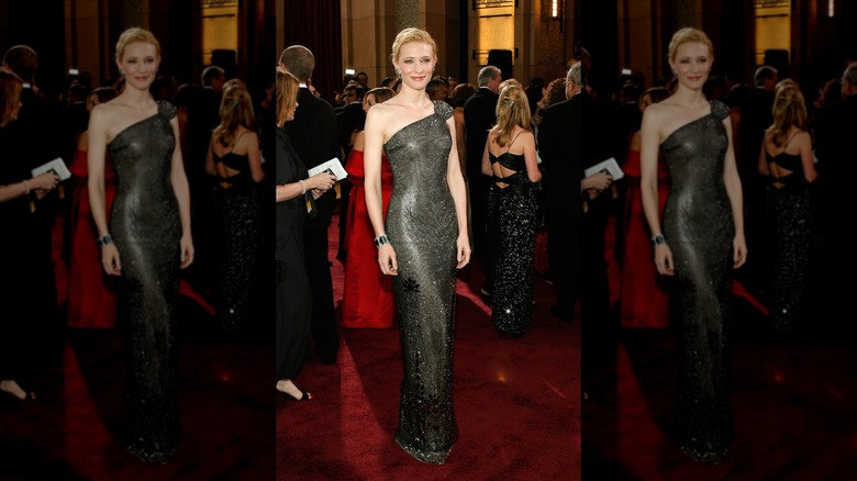 Cate Blanchett sourit dans une robe noire ornée d'une épaule