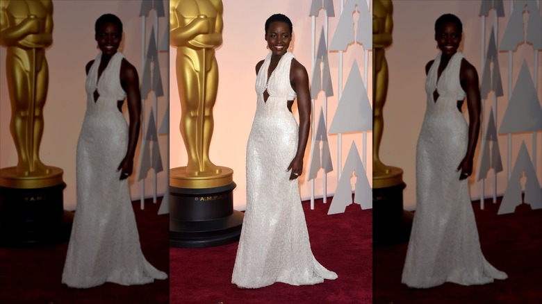 Lupita Nyong'o sourit dans une robe à perles blanches