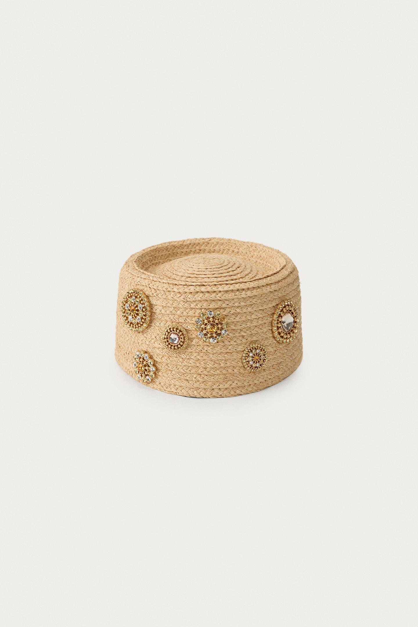 Casquette en raphia avec broches dorées avec pierres.