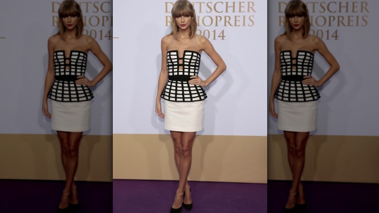 Taylor Swift pose lors d'un événement en 2014 vêtue d'une cage à basque