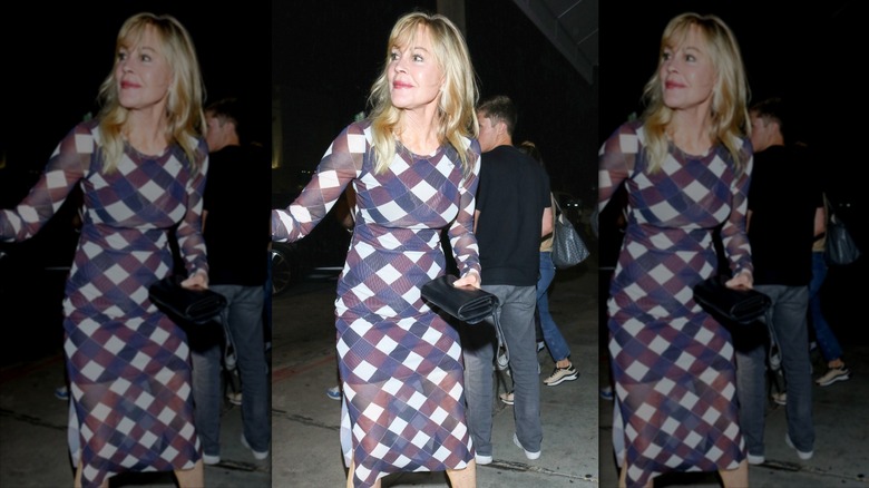 Melanie Griffith regarde à gauche dans une robe midi moulante géométrique