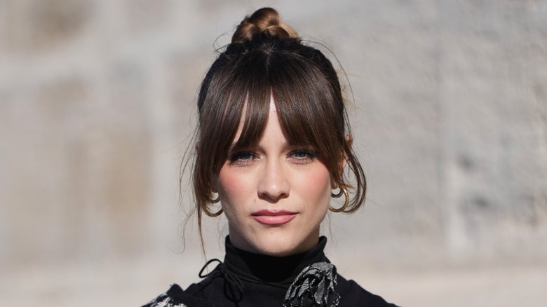 Une femme porte un chignon avec une frange en rideau