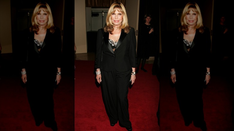 Nancy Sinatra lors d'un événement sur le tapis rouge, vêtue d'une tenue entièrement noire et les cheveux détachés.
