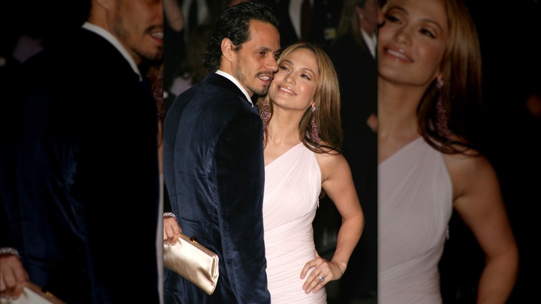 Jennifer Lopez dans une robe rose pâle, souriant à Marc Anthony vêtu d'un costume en daim bleu marine.