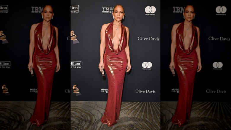 Jennifer Lopez sur le tapis rouge vêtue d'une robe rouge avec un décolleté plongeant spectaculaire.