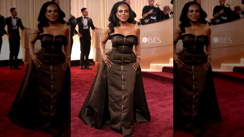 Sheryl Lee Ralph souriante sur le tapis rouge, vêtue d'une robe bustier marron chocolat avec une cape.
