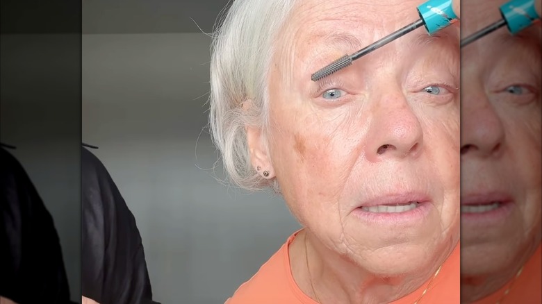 Une femme appliquant du mascara gris