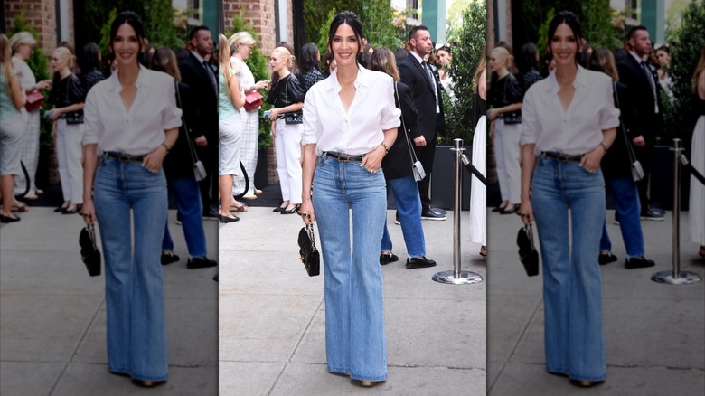 Une femme vêtue d'un bouton blanc et d'un jean.