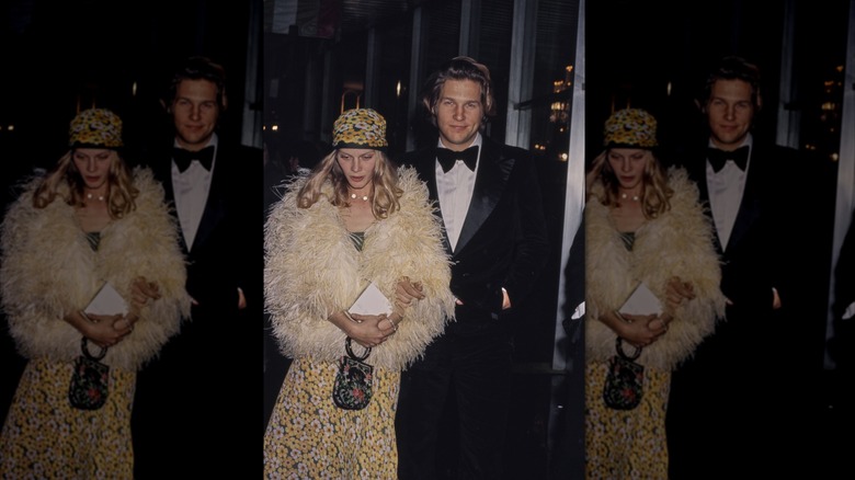 Jeff Bridges en smoking noir et sa femme Susan Geston portant un chapeau à fleurs et une robe avec un manteau à plumes photographiés lors des Oscars de 1975.
