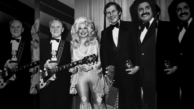 Dolly Parton assistant aux Grammy Awards 1977 portant une combinaison rose à bas cloche.